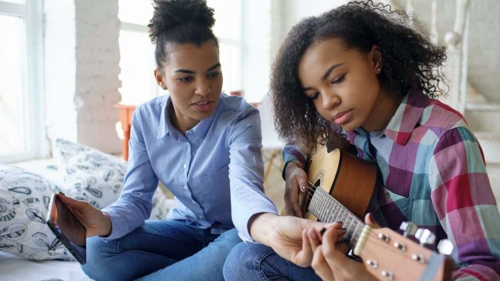 A music teacher and her student during guitar lessons