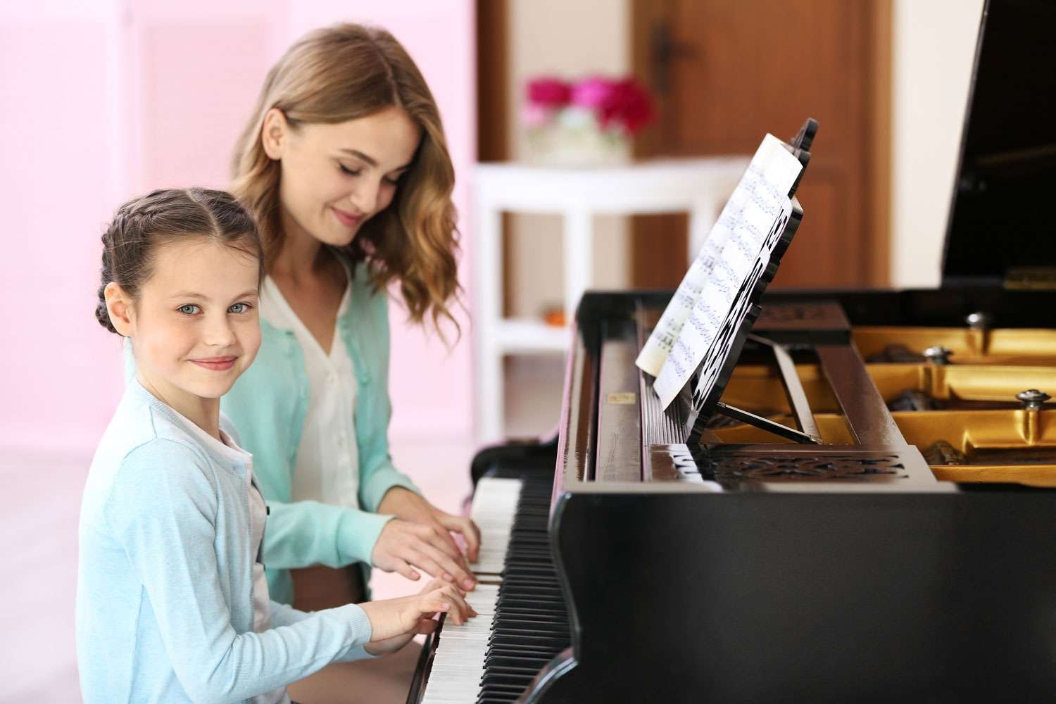 piano instructor and her young student at piano