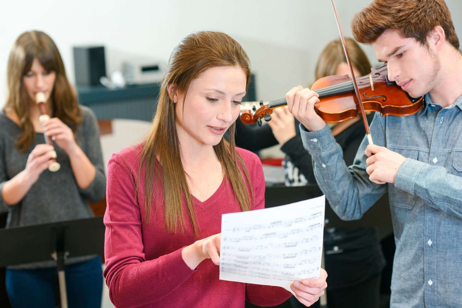 young female instructing male violin student