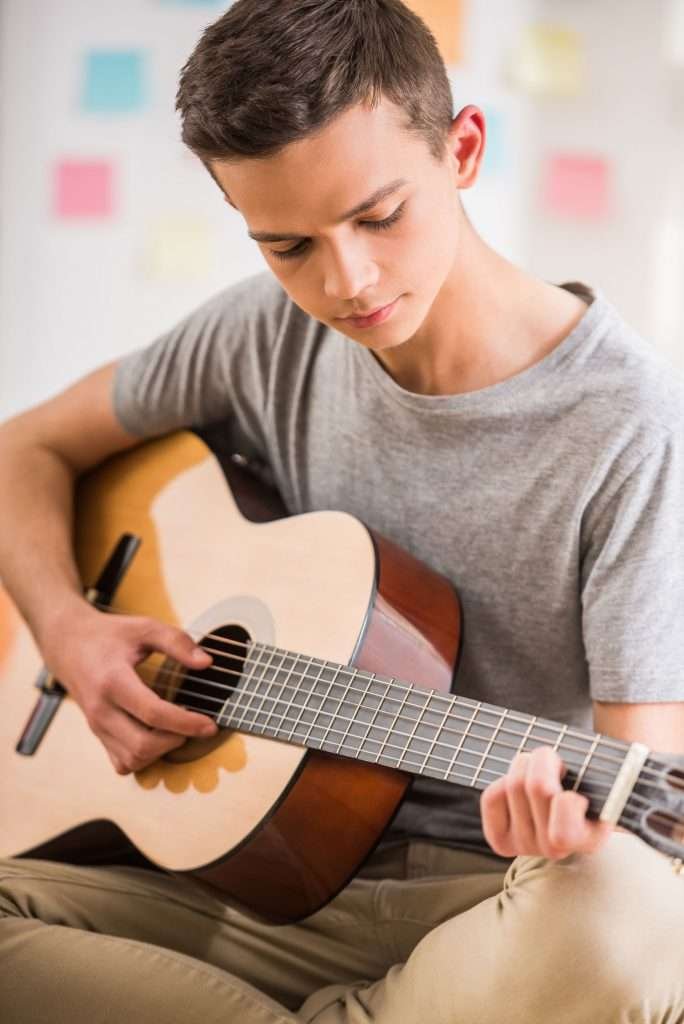 young teen playing the guitar