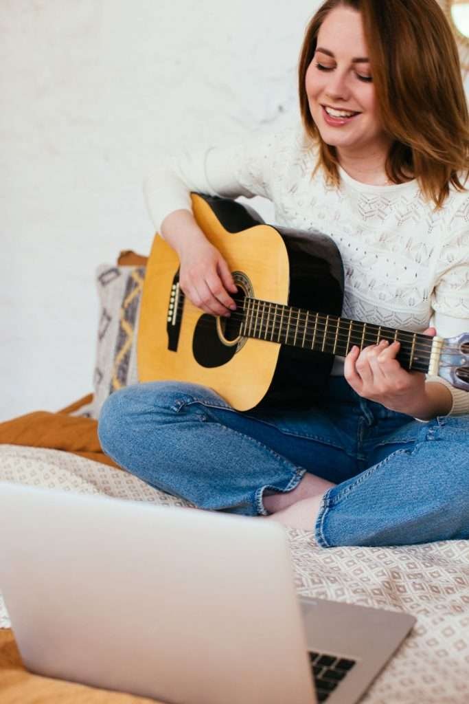 young girl playing guitar and singing