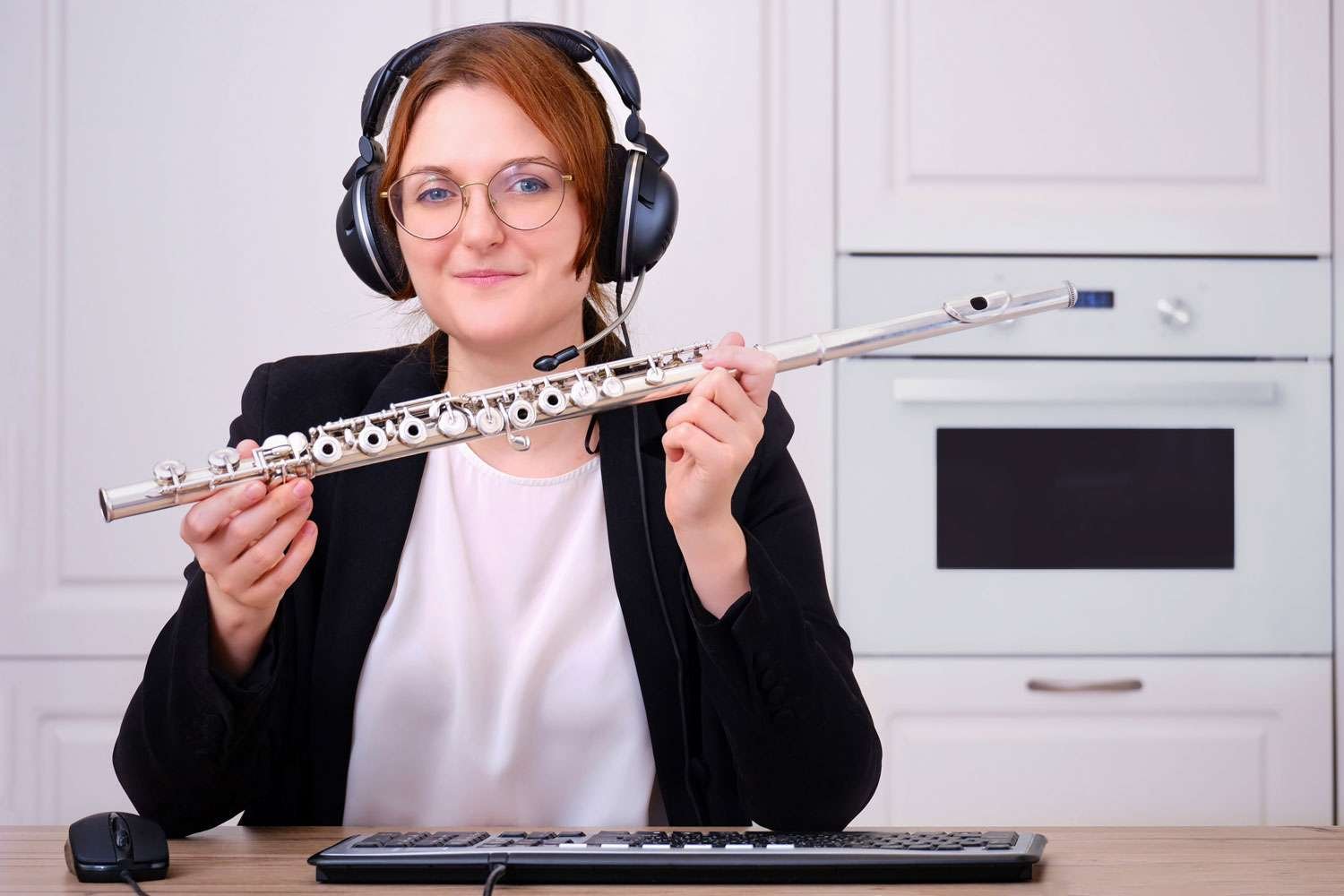young woman holding flute and wearing headphones